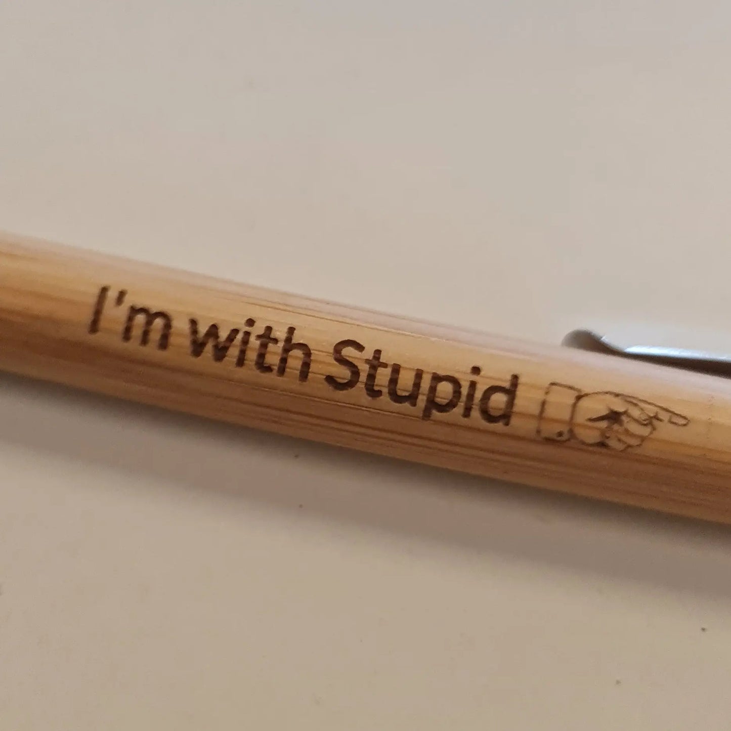 Wooden pen with 'I'm with Stupid' engraving on a light background